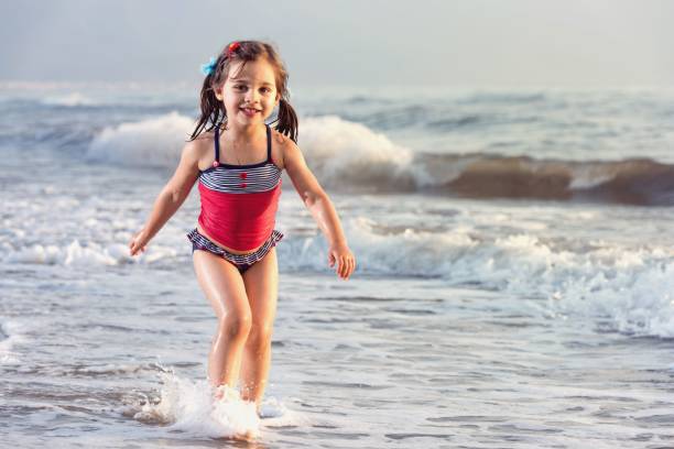 istock Little girl playing in the waves at seaside 655469334