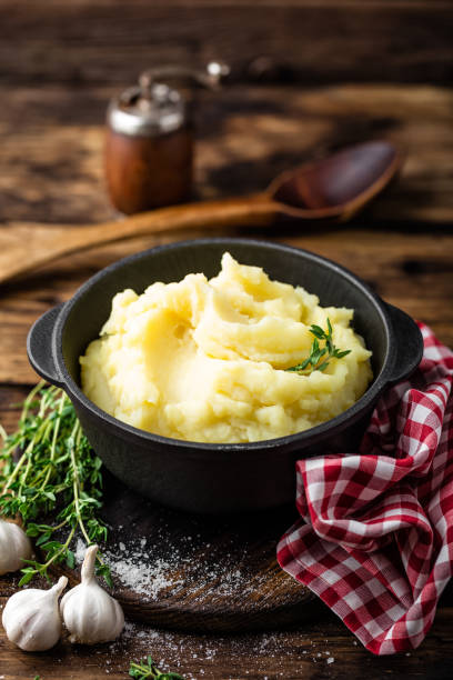 istock Mashed potatoes, boiled puree in cast iron pot on dark wooden rustic background, top view 655471620