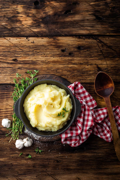 istock Mashed potatoes, boiled puree in cast iron pot on dark wooden rustic background, top view 655472104