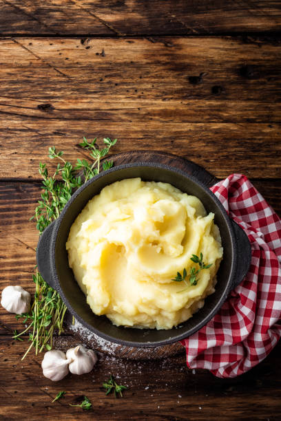 istock Mashed potatoes, boiled puree in cast iron pot on dark wooden rustic background, top view 655472268