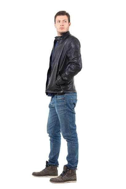 istock Side view of young man in leather jacket and jeans looking back over the shoulder. 655472394