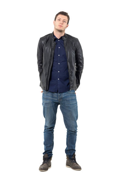 istock Young man in leather jacket and jeans with hands behind back and titled head 655475142