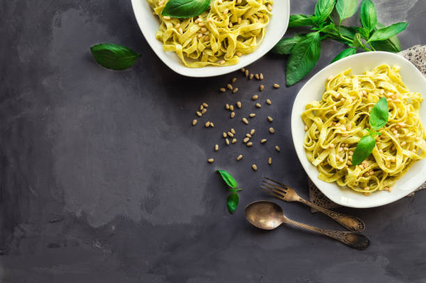 istock Fettuccine pasta with pesto sauce, basil and pine nuts on concrete background 655475536