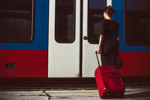 istock Elegant woman with a suitcase boarding the train 655475872