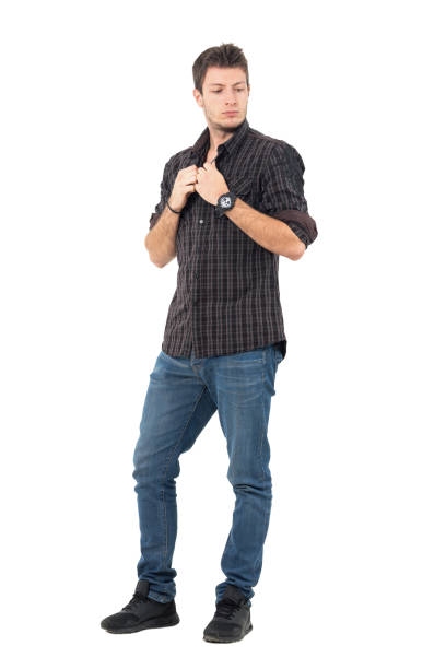 istock Young handsome casual man buttoning plaid shirt looking down. 655475998