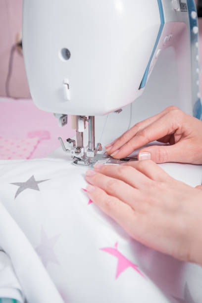 istock Woman's hands with dress at sewing machine 655484446