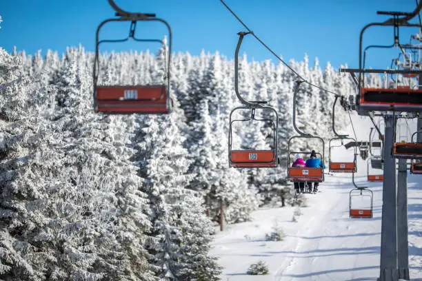 Photo of Ski lift with skiers being carried up the hill