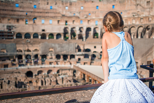 Happy toddler girl in Rome over Coliseum background
