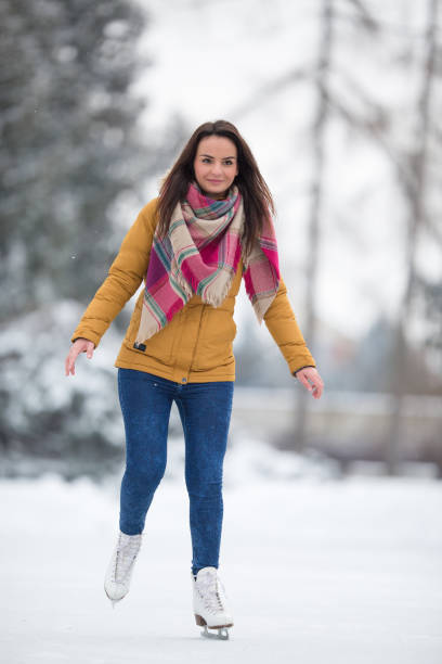 istock Young woman ice skating outdoors on a pond 655540794