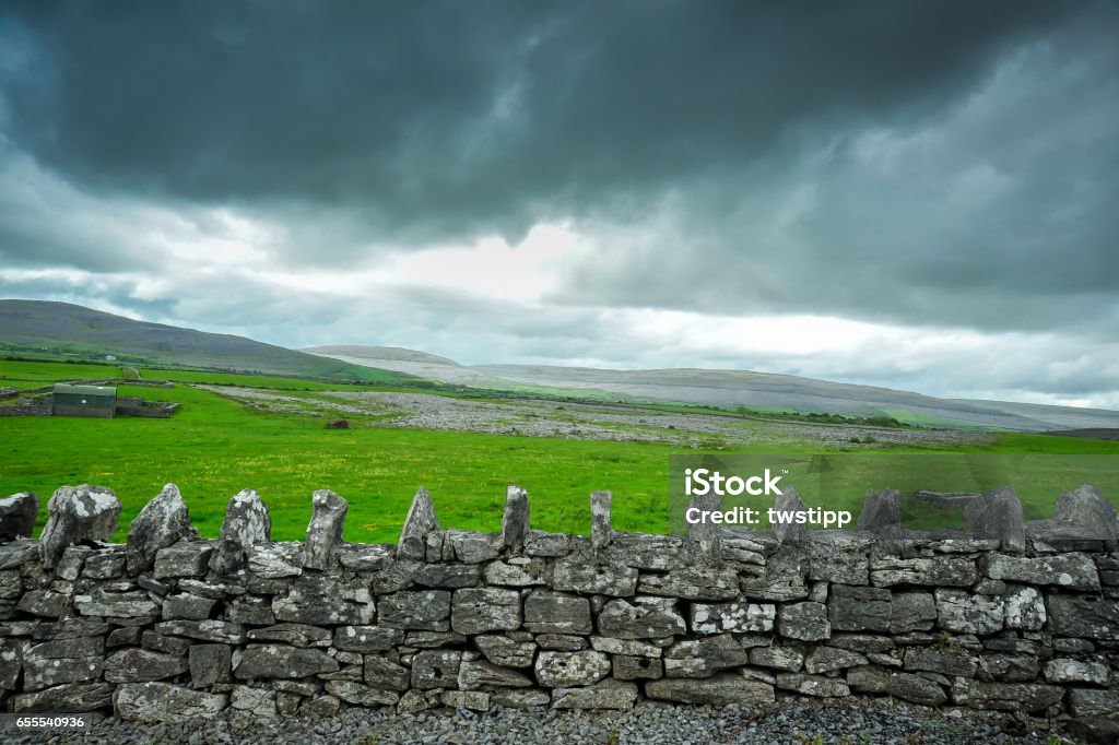 Storm cloulds and old stone wall Ancient stone wall, barn, and storm clouds, on the outskirts of Kinvara, County Galway, Ireland Galway Stock Photo