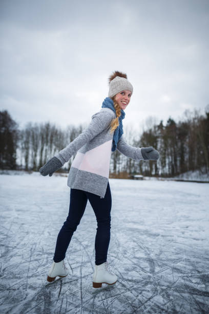 istock Young woman ice skating outdoors on a pond 655548514