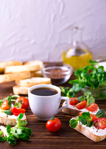 istock Bruschetta with ricotta, corn salad and cherry tomatoes. Coffee. 655552036