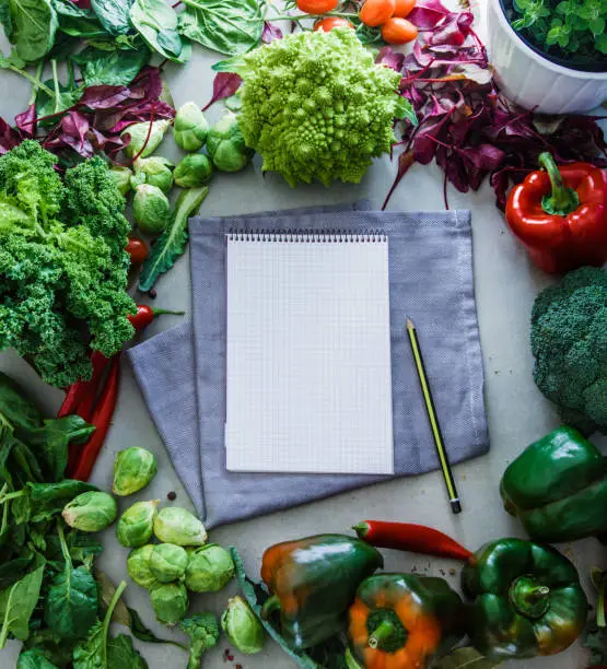 Fresh vegetables flatlay overhead frame. Open Notebook with vegetables.. Food layout. Diet. Dieting plan