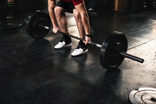 Close up of a man doing deadlift in the gym.