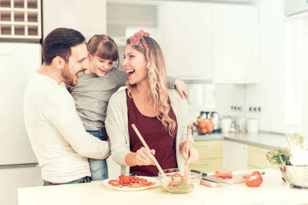 счастливая молодая семья на кухне - family with one child domestic life caucasian love стоковые фото и изображения