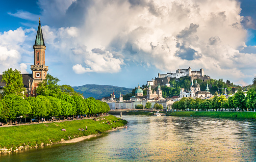 Colorful Dinant Cityscape at the waterfront of River Meuse under blue summer sky.  Famous Notre Dame de Dinant Collegial Church - Collégiale Notre Dame de Dinant - Church of Our Lady from the 13th-century, old gothic cathedral and huge limestone cliff with Dinant Citadel Fortress on top behind the town of Dinant. 102 MPixel Hasselblad X2D Cityscape. Dinant, Wallonia, Namur, Belgium, Europe.