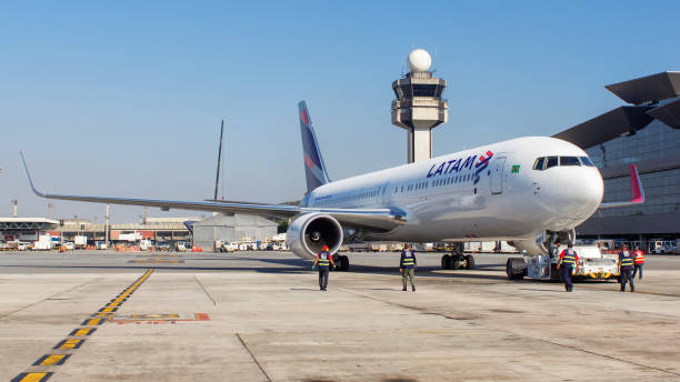 boeing 767 de latam airlines push con torre de control de tráfico aéreo en fondo en aeropuerto internacional de guarulhos en sao paulo brasil - runway airplane landing landing light fotografías e imágenes de stock