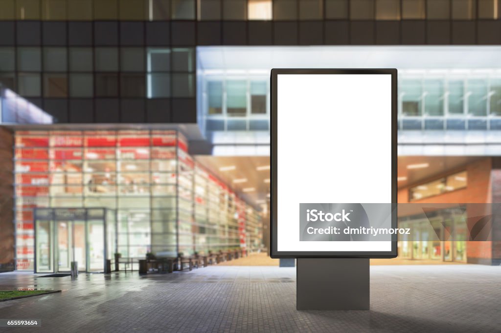 Blank advertising stand Blank advertising stand at night against contemporary office building and shopping mall. 3d render Shopping Mall Stock Photo