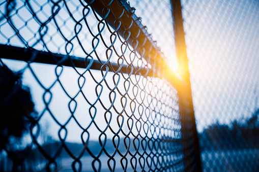 full frame shot of mesh wire fence in blue tone.