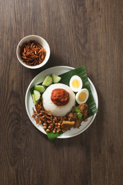 Malaysian traditional food "Nasi Lemak" on rustic wooden table top. Malaysian traditional food "Nasi Lemak" on rustic wooden table top.. Overhead view. traditional malaysian food stock pictures, royalty-free photos & images