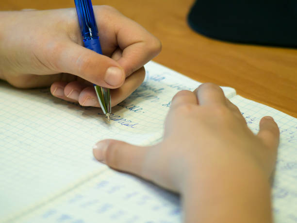 istock Girl writing closeup. Pencil in hand. 655619740