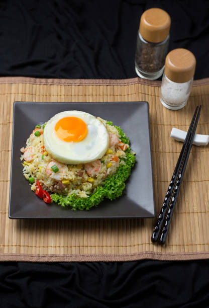 istock Chinese food fried rice with egg on black colour plate on bamboo mat. 655623806