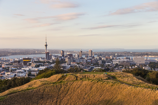 Sunset over Auckland business district from the Mount Eden in New Zealand largest city. The volcano crater is in the foreground.