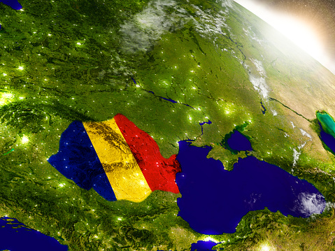 Romania with embedded flag on planet surface during sunrise. 3D illustration with highly detailed realistic planet surface and visible city lights. 3D model of planet created and rendered in Cheetah3D software, 9 Mar 2017. Some layers of planet surface use textures furnished by NASA, Blue Marble collection: http://visibleearth.nasa.gov/view_cat.php?categoryID=1484
