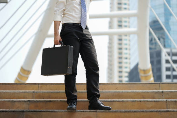 istock Businessman stand alone holding document bag at ladder after working 655631758