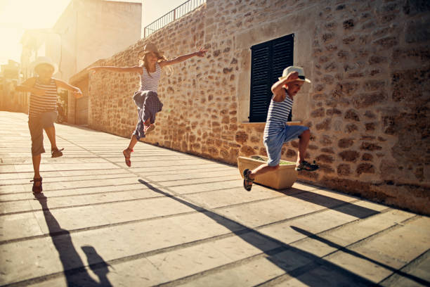 Kids tourists running and jumping in mediterranean street. Three kids tourists running and having fun in the beautiful mediterranean town of Alcudia. 


 bay of alcudia stock pictures, royalty-free photos & images