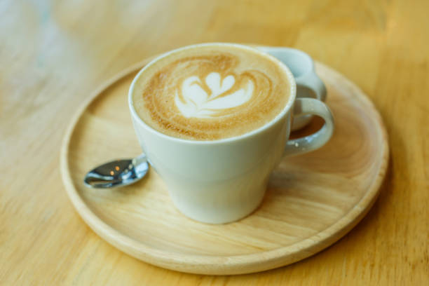 istock cup of coffee with heart pattern in a white cup on wooden background 655637378