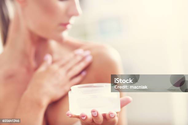 Picture Of A Fit Woman Holding Lotion Over Her Body Stock Photo - Download Image Now