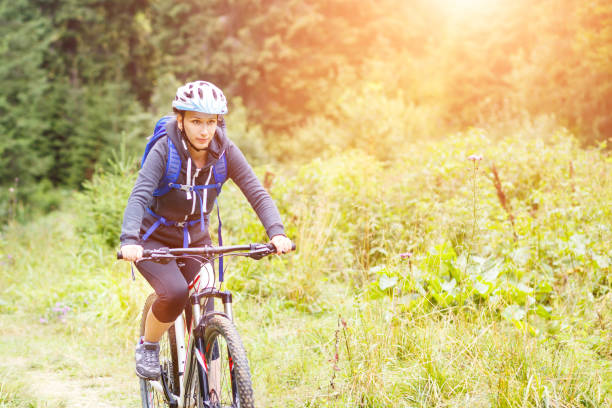 istock Young woman riding bicycle in mountain forest 655644672