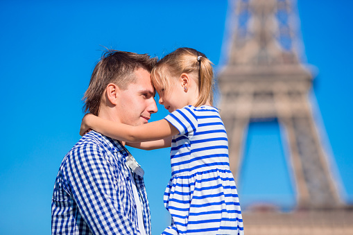 Happy dad and little adorable girl traveling in Paris near Eiffel Tower