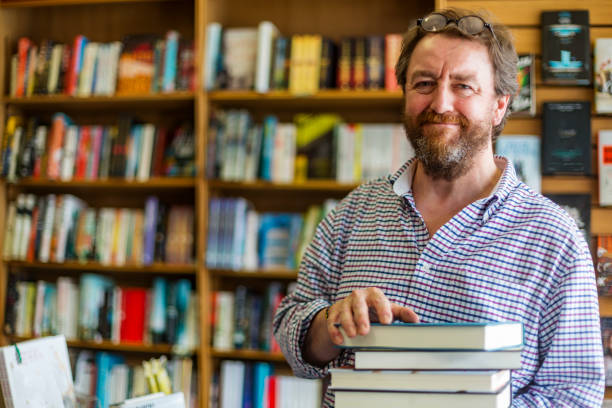 shopkeeper working in a traditional english bookshop - bookstore imagens e fotografias de stock