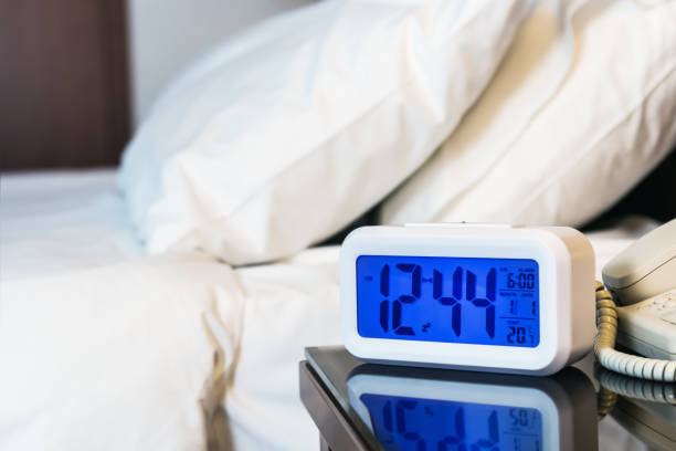istock Alarm clock electronic stands on a bedside table near the bed 655659616