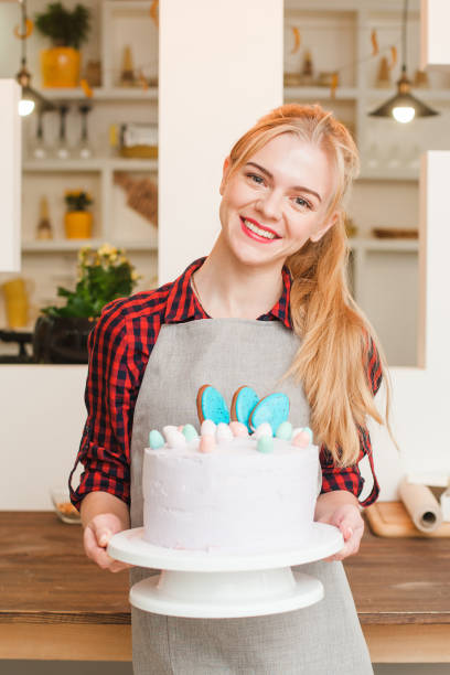 キッチンで白いケーキを持つ女の子。料理のデザート。 - cake women confectioner photography ストックフォトと画像