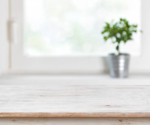 istock Light wooden texture table on defocuced summer window background 655678090