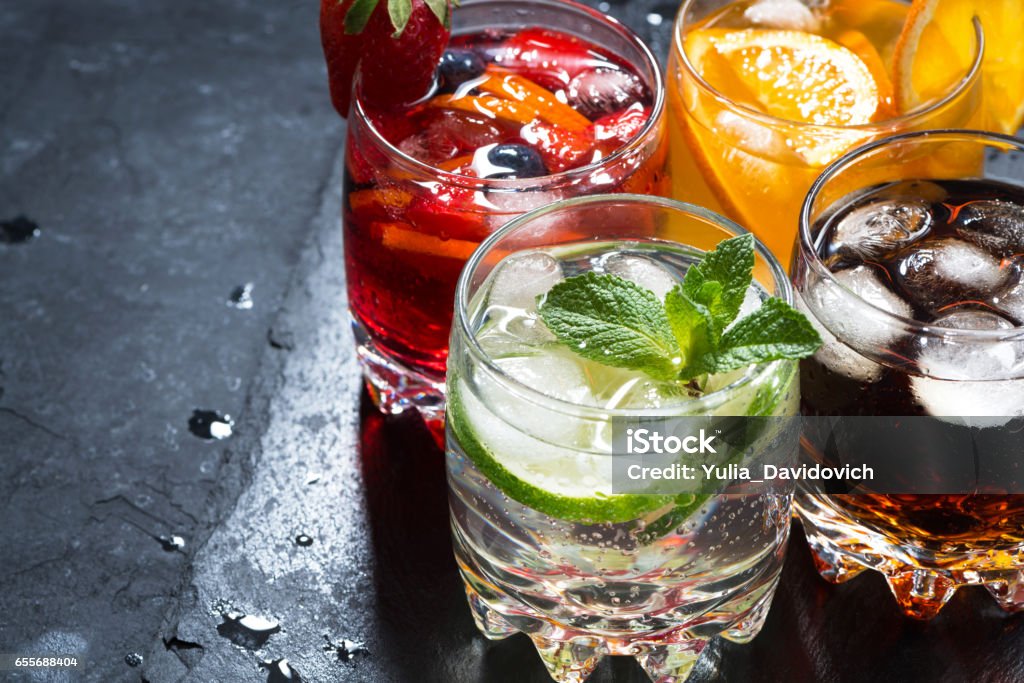 assortment of fresh iced fruit drinks on a black background assortment of fresh iced fruit drinks on a black background, closeup Cold Drink Stock Photo