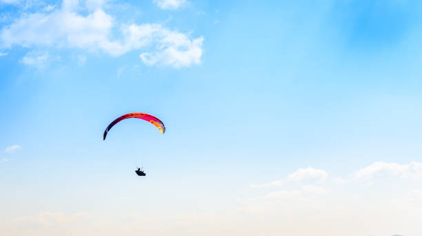 istock Paraglider flying against the blue sky with white clouds. 655691714