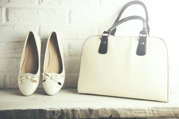 istock Woman white  shoes and bag on brick wall  background 655691966