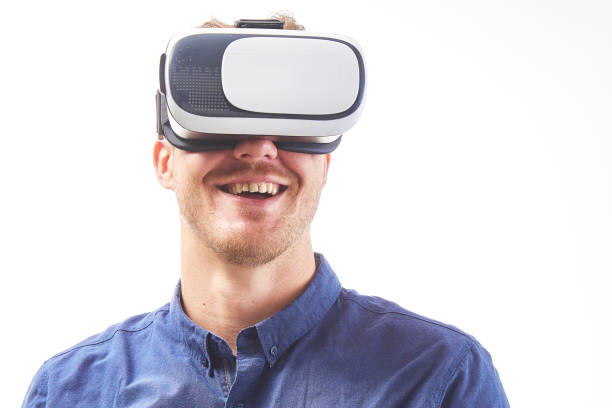 istock Amazed young man looking in a VR goggles and smiling  studio shot on white background