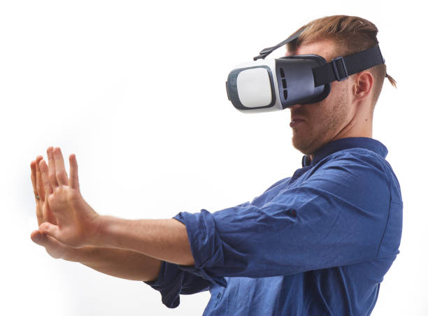 istock Young man Using VIrtual Reality Glasses for first time looking on his hand thru VR Glasses studio shot on white background 655692698