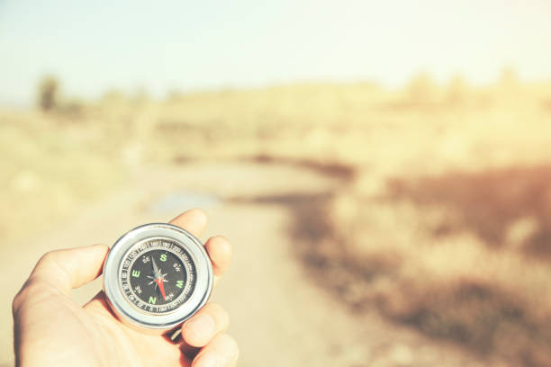 istock Hand man holding compass navigator on road way 655696758