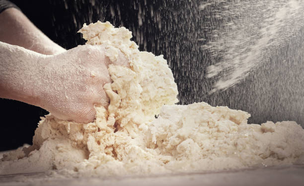 Making dough by female hands at home in kitchen
