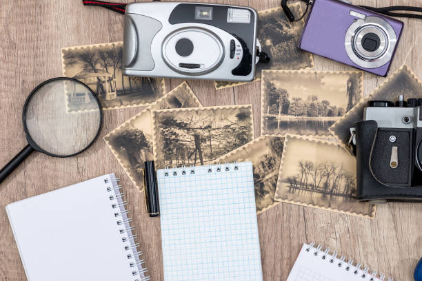 istock old camera with pictures and blank notepad on desk. 655702602