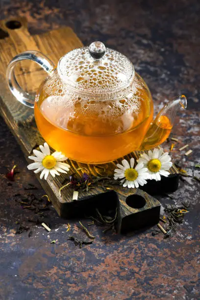 chamomile tea in a glass teapot, top view