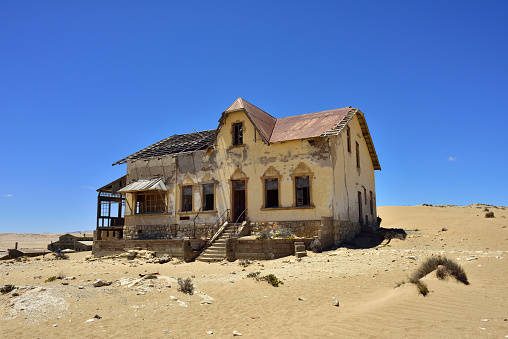 The abandoned ghost diamond town of Kolmanskop in Namibia, which is slowly being swallowed by the desert