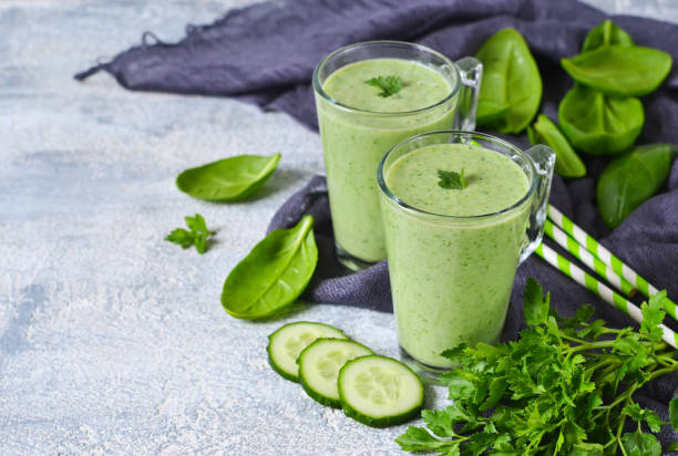 istock Green vegetable smoothie with avocado, cucumber and spinach on a gray background 655721960
