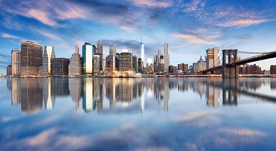 Lower Manhattan and the Freedom Tower under a colorful sunset in summer.